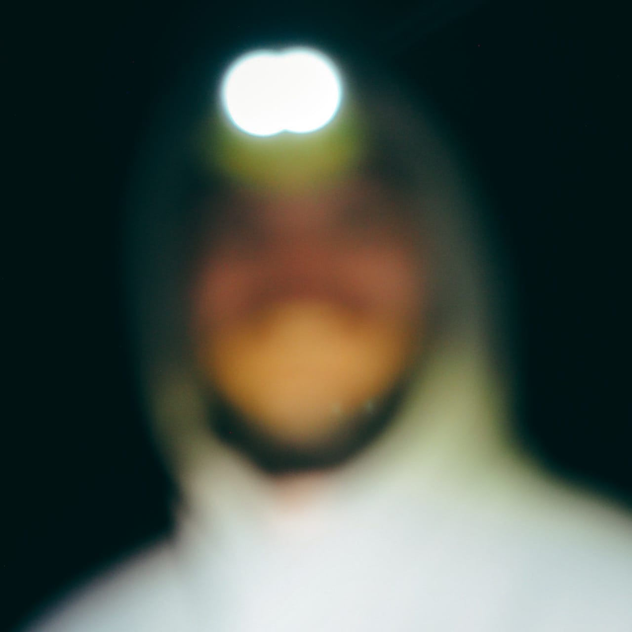 Blurry photo of William Davy with a head torch